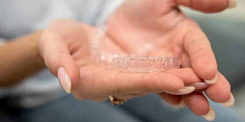 Closeup of patient holding clear aligner