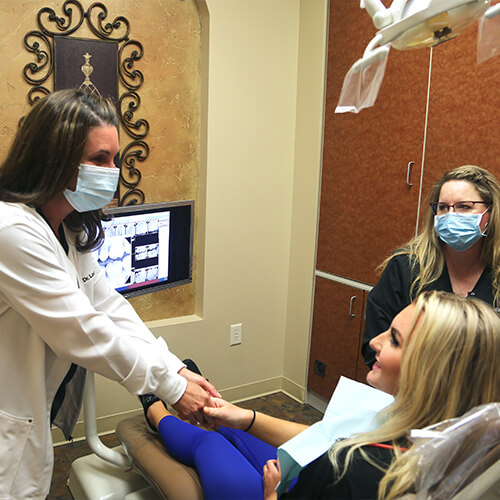 Dentist greeting dental patient in dental treatment room