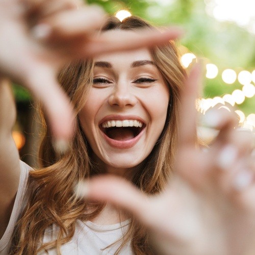 Woman showing offer her smile after smile makeovers