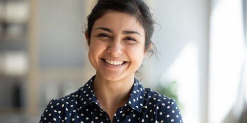 Woman wearing a spotted shirt and smiling