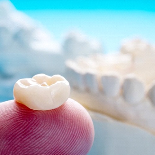 Closeup of dental crown in Flower Mound on finger