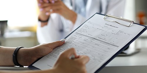 a patient filling out forms on a clipboard