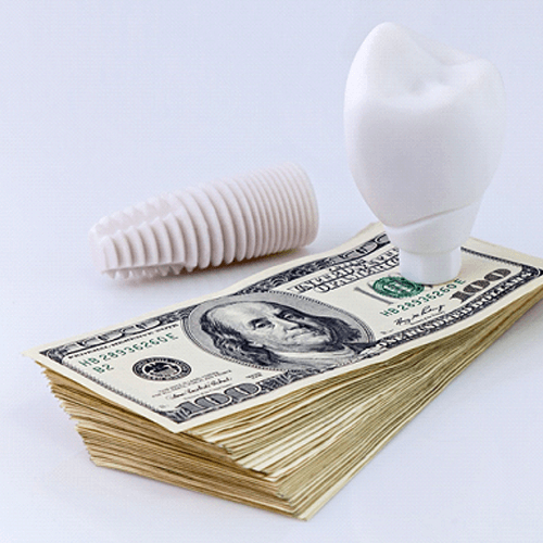 An implant sitting on a stack of cash, symbolizing the cost of dental implants in Flower Mound