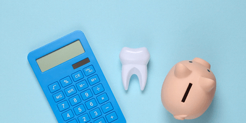 A calculator, tooth, and piggy bank, symbolizing the cost of dental implants in Flower Mound