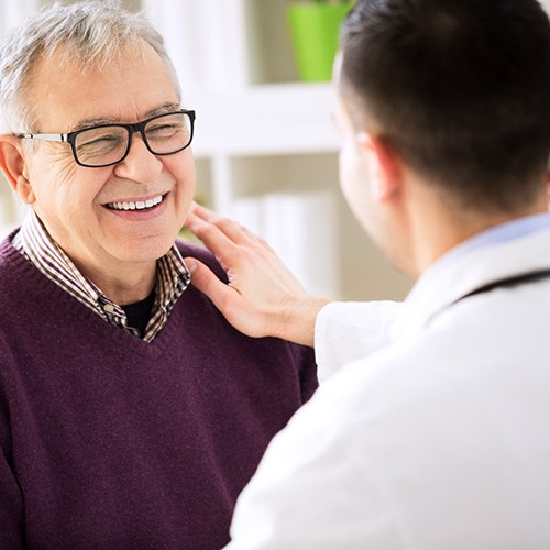 Man with implant dentures smiling at his Flower Mound implant dentist 