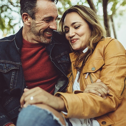 Man and woman enjoying the benefits of tooth replacement with dental implants