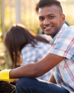 Young man smiling outdoors during community event