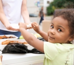 Child interacting with dental team member at community event