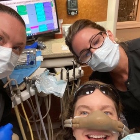Dental team member taking selfie with patient in dental treatment room