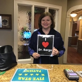 Dental patient holding a sign reading I love Doctor Barge