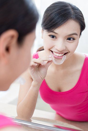 Woman placing an Invisalign clear aligner tray