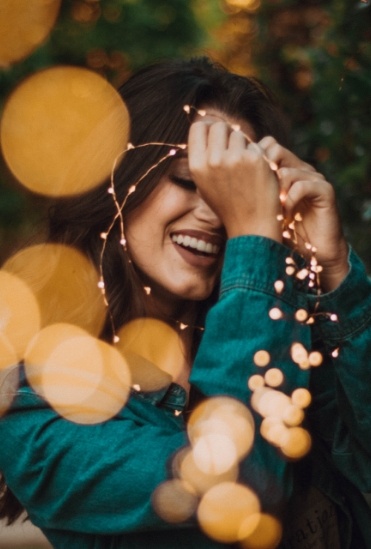 woman smiling around lights in Flower Mound