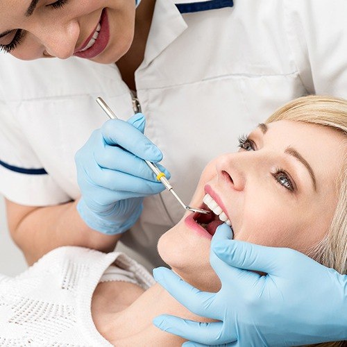 Woman receiving dental checkup and teeth cleaning