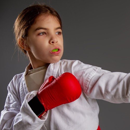 Young person boxing with green athletic mouthguard in place