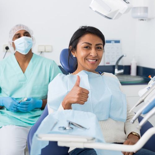 a dental patient giving a thumbs up 