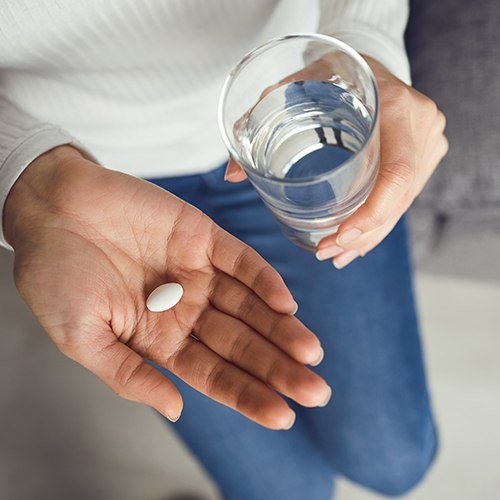 Patient holding an oral conscious dental sedation pill