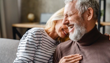 Man and woman smiling together after restorative dentistry