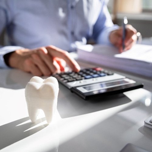 A man calculating the cost of dental veneers