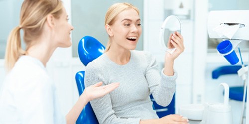 A woman admiring the results of cosmetic dentistry