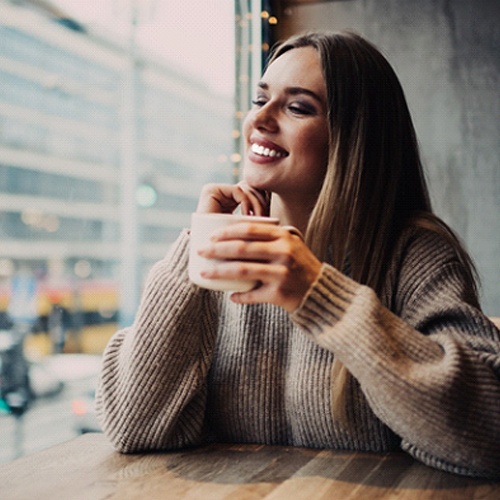 Woman with veneers in Flower Mound drinking coffee