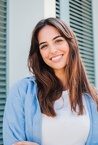 Woman with white teeth smiling while standing outside