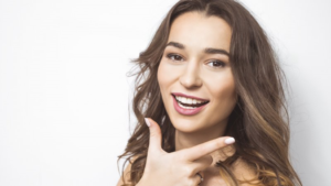 a patient pointing toward their healthy smile 