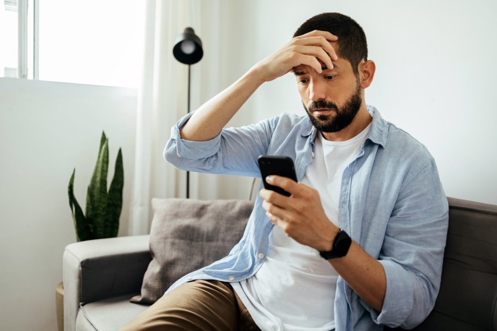 Man looking concerned while looking at phone