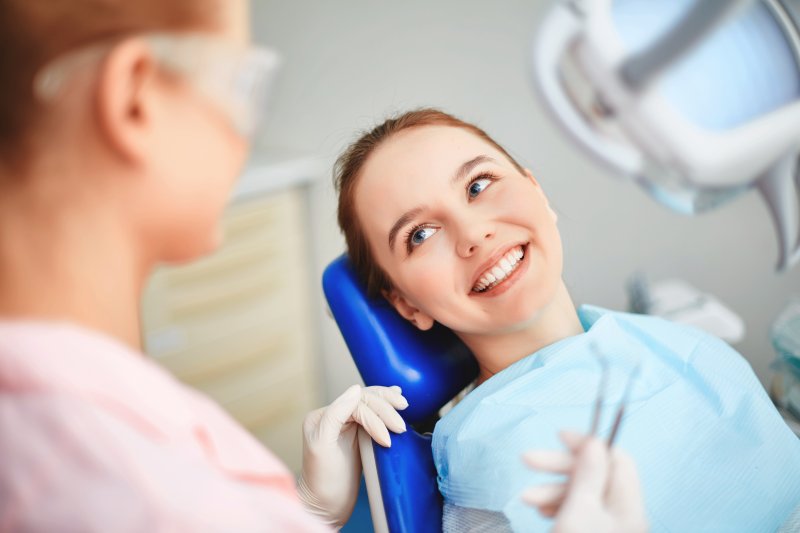 Young woman smiling in dentist chair up at dentist