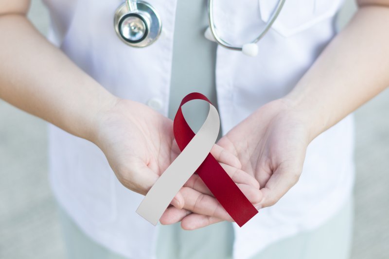 Woman holding an oral cancer ribbon