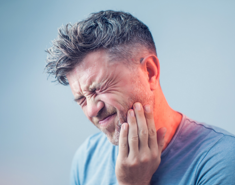 Man holding jaw with tooth pain