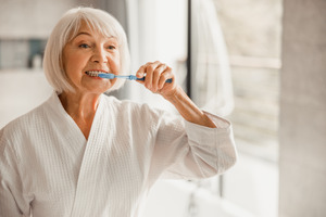 Senior woman brushing her teeth