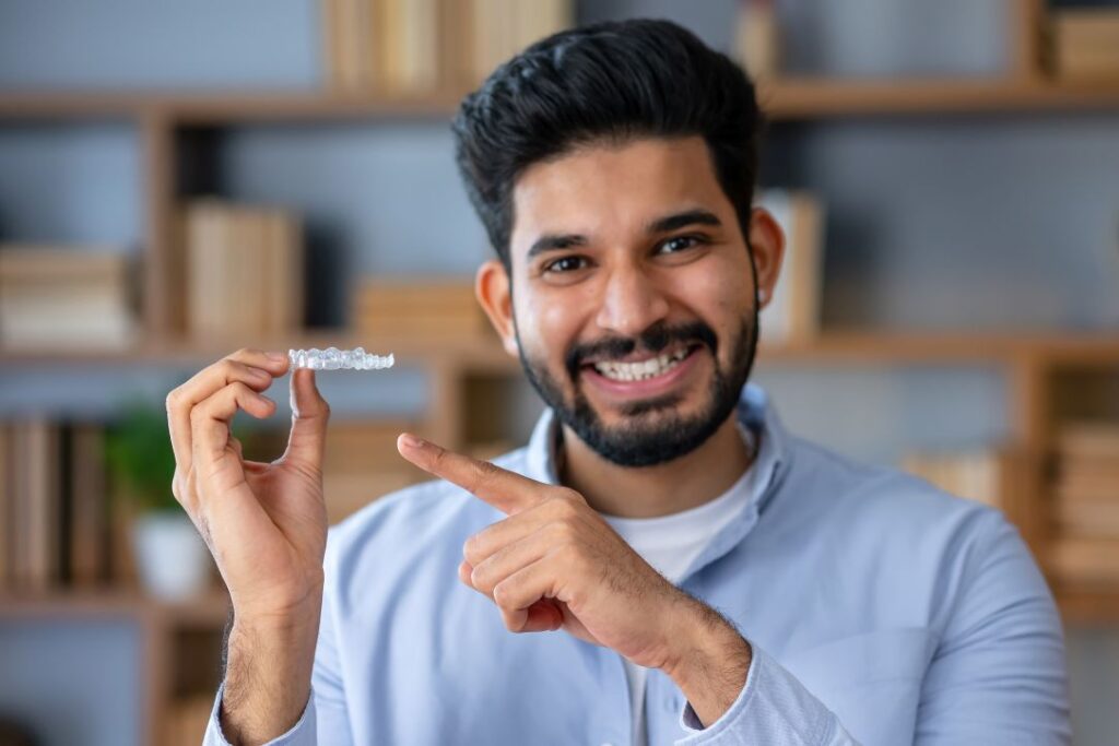 A man holding an Invisalign aligner